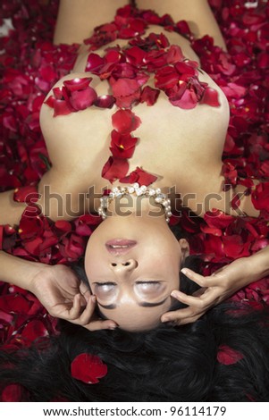 A sexy woman enjoying bath flower with rose petals