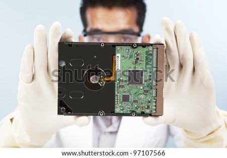 A scientist showing a computer harddisk shot in laboratory