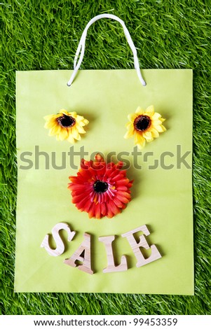 Sale shopping bag design on green grass. Shot outdoor in meadow