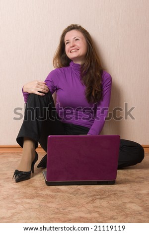 Happy young woman sit on a floor with purple notebook.