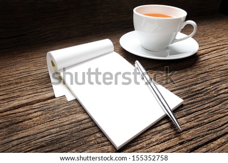 blank white notebook with cup of tea on desk