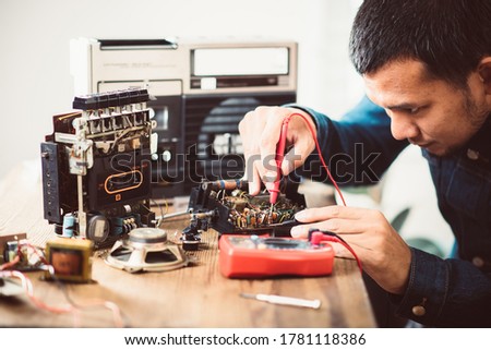 Technician repairing an old radio cassette recorder.