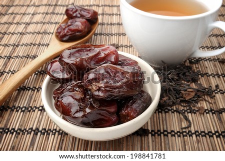 closeup sweet dried dates fruit with tea