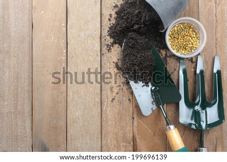 gardening tools on wooden plank background