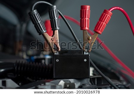 Car battery with red and black battery jumper cable. Foto stock © 