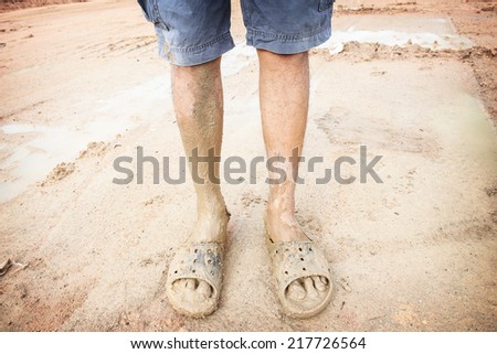 man wearing dirty sandals after mired in the mud with filtered