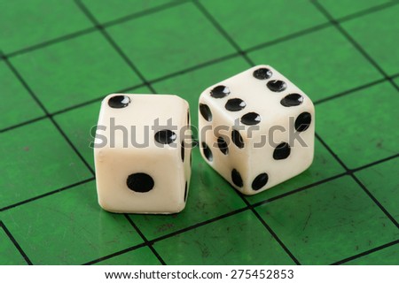two old plastic dice on green background