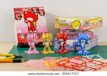 CHONBURI, THAILAND - AUGUST 10, 2015: Four different colour of assembled Petit\'gguy model kits with boxes on cutting mat.