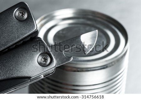 opening the tin with tin opener (can opener)