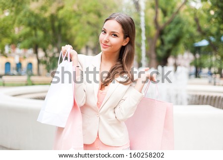 Portrait of a young brunette beauty with shopping bags.