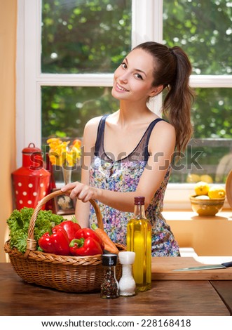Fit brunette beauty preparing healthy food in the kitchen.