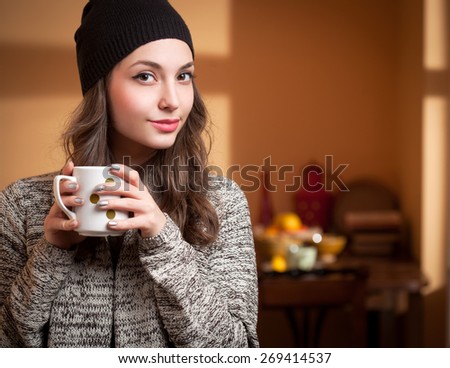 Portrait of a gorgeous young brunette relaxing with cup of hot beverage.