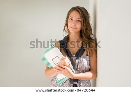 Beautiful relaxed young student girl with exercise books.