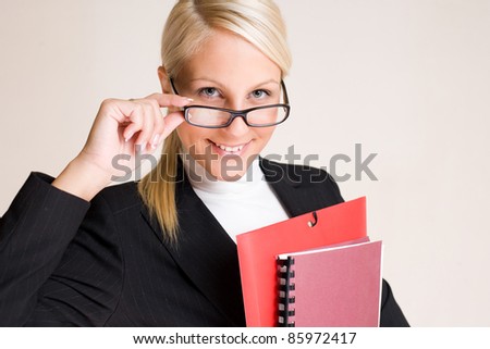 Portrait of beautiful friendly smiling businesswoman peeking over her glasses.