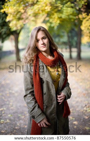 Half length portrait of stylish autumn fashion girl in the park.