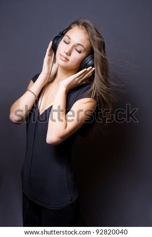 Artistic portrait of a beautiful young brunette girl immersed in music meditation