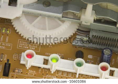 Circuit board with gears, LED lights (a red and green are on), spring and transiters