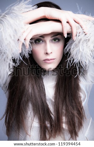 fashion woman portrait  in elegant silver jacket with feathers on the sleeves studio shot