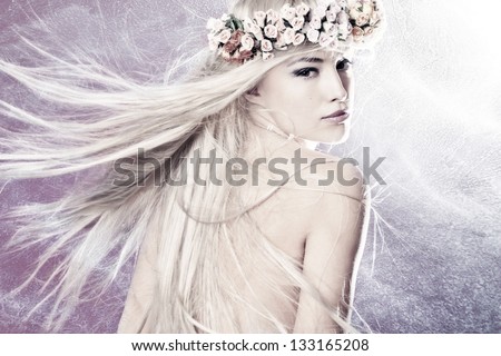beautiful young woman with long blond flying hair and wreath of flowers
