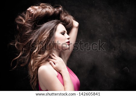 young woman portrait with long shiny healthy hair studio dark background