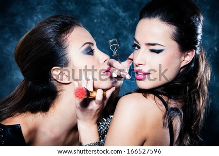 couple of girls makeup each other preparing to go out