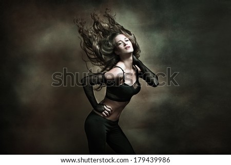 attractive young woman dancing long hair fly , studio shot