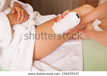 woman at cosmetics salon waxing legs