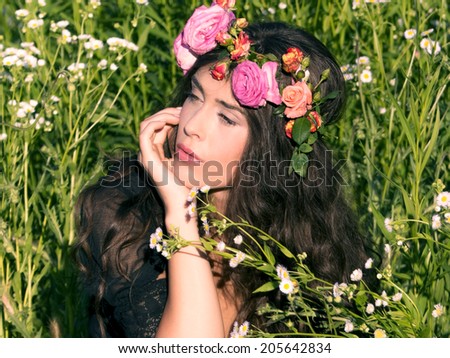 woman in field with flowers in hair