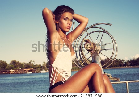 attractive young woman on the bow of a fishing boat sunny summer day on sea