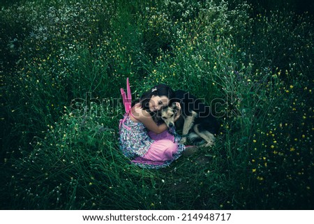 girl like a fairy sitting in grass meadow  hugs lost dog shot from above