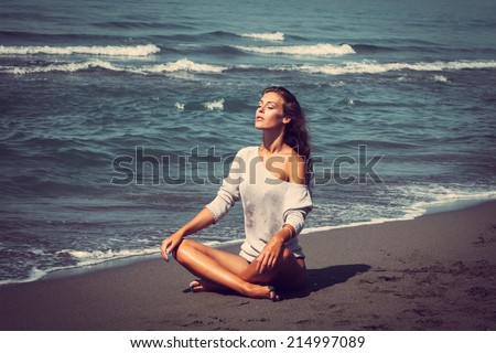young woman enjoy in sun on sandy beach by the sea full body shot