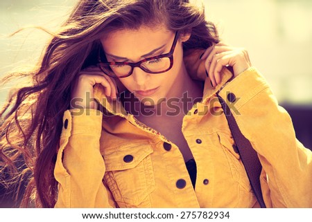 young urban woman with eyeglasses portrait,  outdoor shot in the city, retro colors