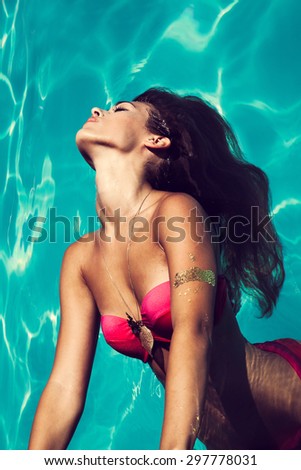 young attractive woman in  in pool with head thrown back above view