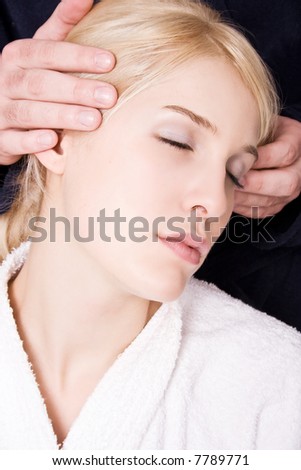 blond woman in white towel and mans hands massage her head