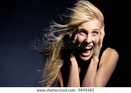 young blond woman screaming in fear, studio