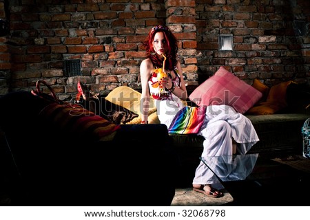 young woman with juice by brick wall