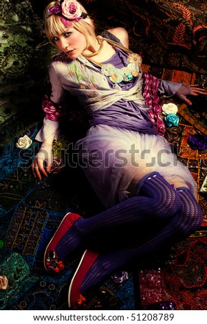 beautiful blond woman in colorful romantic clothes, lie down, studio shot