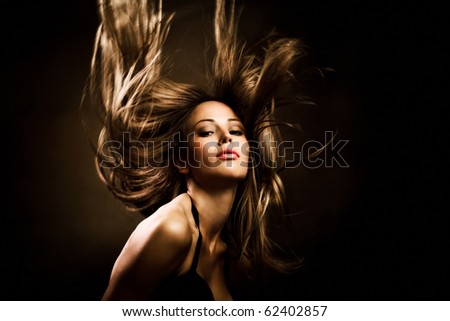 beautiful woman with long golden hair in motion, studio shot