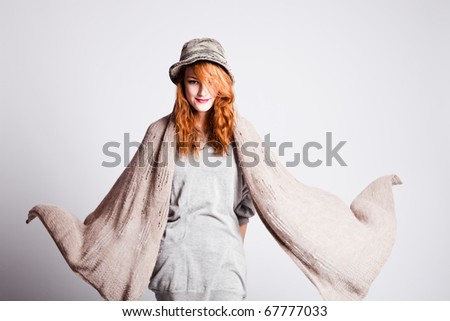 young   woman in winter  clothes with flying wool scarf, studio shot