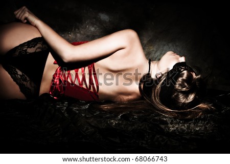 sensual blond woman in lingerie  and lace over eyes lie down, studio dark