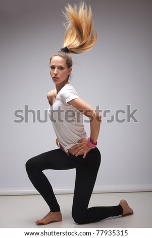 young blond woman in white t-shirt dancing, studio shot, full body shot