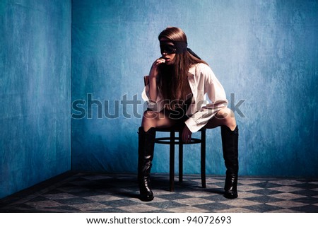 woman with lace over eyes in white shirt and boots sit in old grunge room, small amount of grain added