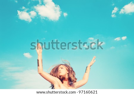 beautiful young woman jump against blue sky with clouds small amount of grain added