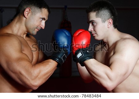 Two young sportsmen box each other in boxing gloves