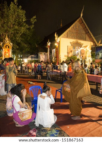 CHIANGMAI THAILAND-AUG. 21 : Night give food offerings.Unidentified women attending the night offering alms to adopted the traditions come together.on Aug.21,2013 in Chiangmai,Thailand