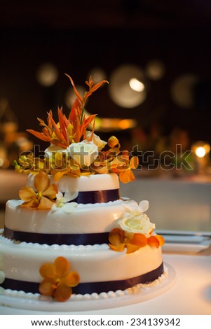 Wedding cake; Set the focus on the flowers on top of the wedding cake.