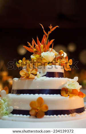 Wedding cake ; Set the focus on the flowers on top of the wedding cake.