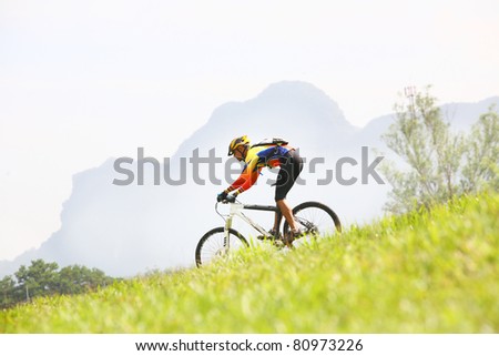 Person riding a bike downhill  to the river