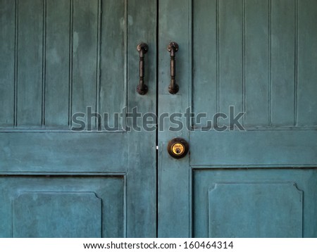 Doorknob and Metal door handle on Vintage Blue door