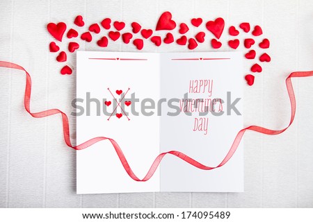 Empty postcard with Happy Valentine\'s Day typography and a red ribbon with fabric hearts on textured background. Valentine Day design.